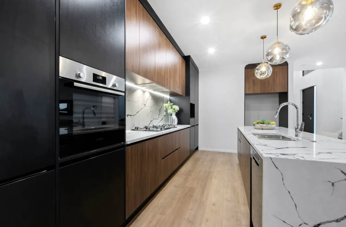 Compact black and timber kitchen with integrated appliances