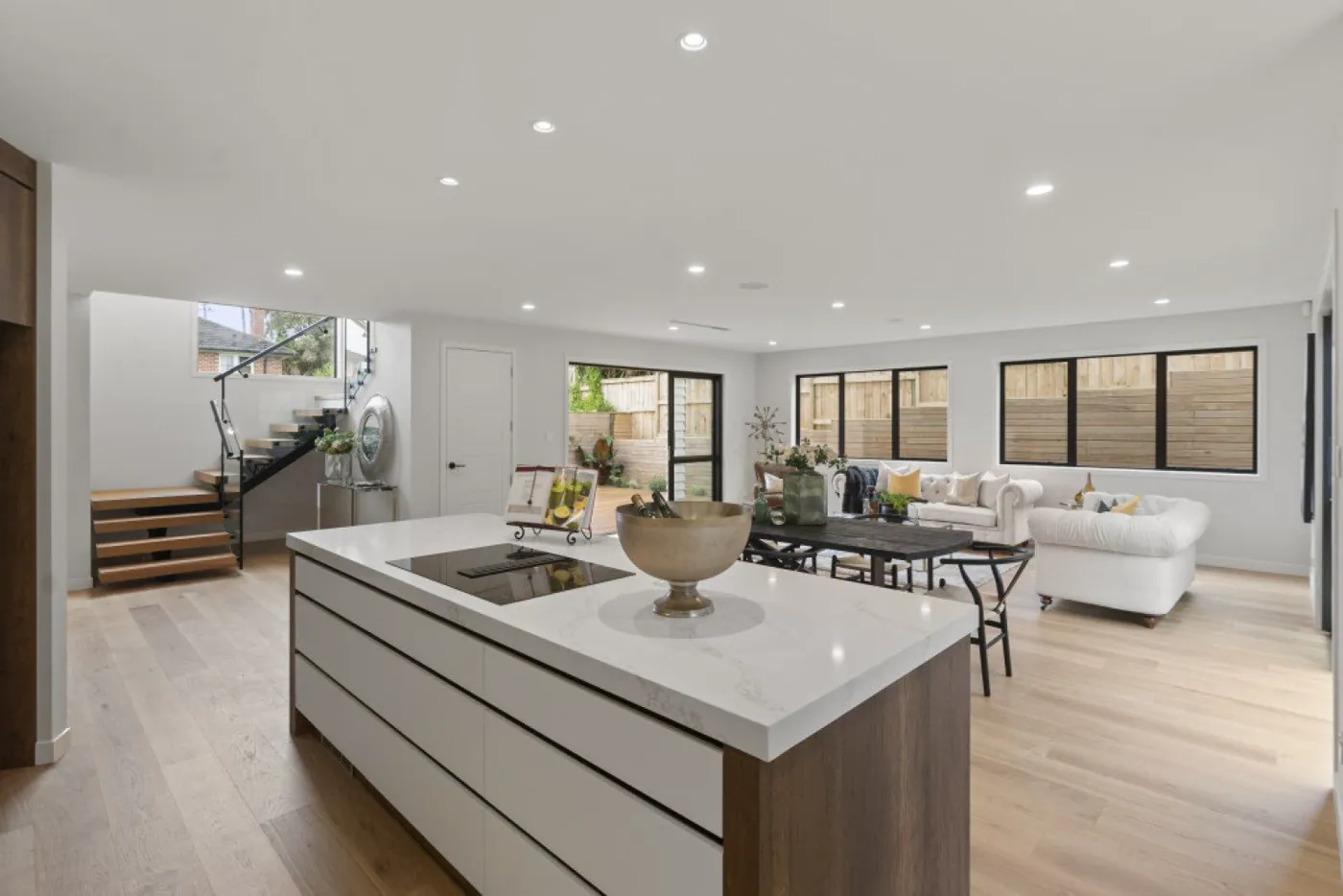 Light kitchen with a long central island and timber feature wall